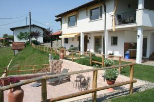 a house with a wooden fence and a patio at B&B Maggiora 131 in Acqui Terme
