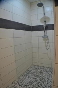 y baño con ducha y azulejos blancos y negros. en Sur la route de champ colin, en Saint-Denis-lès-Rebais
