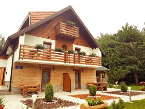 a large wooden house with a balcony at Guesthouse Green Valley in Plitvička Jezera