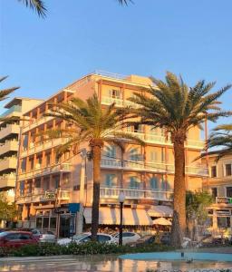 a large building with palm trees and palm trees at Achillion Hotel in Rhodes Town