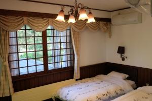 1 dormitorio con 2 camas y ventana en Appikogen Pension Mutti, en Hachimantai