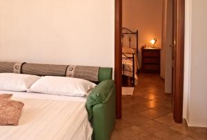 een slaapkamer met een bed en een groene bank bij Agriturismo Sa Suerera in Olmedo