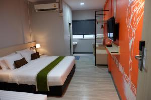 a hotel room with two beds and a television at Siam Stadium Hostel in Bangkok