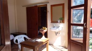 a bathroom with a table and a sink and a table and chair at Rura Raya Homestay in Rantepao