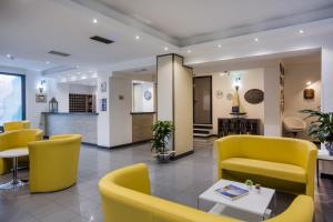 a waiting room with yellow chairs and a table at Hotel Riviera 3 Stelle con piscina estiva gratuita e garage a pagamento in Spotorno