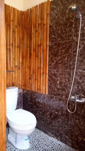 y baño con aseo y ducha. en Rura Raya Homestay, en Rantepao