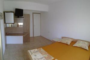 a bedroom with a bed and a flat screen tv at Eleonor Guest House in Byala