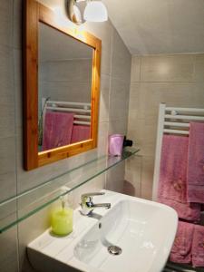 a bathroom with a sink and a mirror and pink towels at Sally's B&B in Carrara