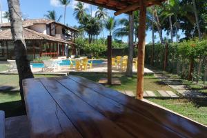 een houten tafel voor een huis bij Residencial Frente a Praia in Porto Seguro