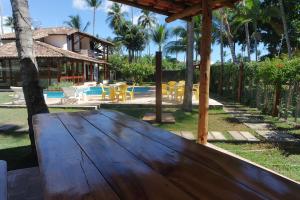 a wooden table in front of a house at Residencial Frente a Praia in Porto Seguro
