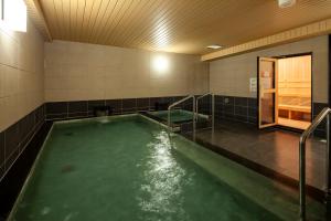 a swimming pool with green water in a bathroom at Y's CABIN&HOTEL Naha Kokusai Street in Naha