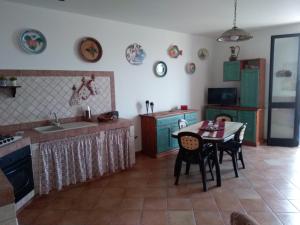 アルカモ・マリーナにあるHolyday on the beachのキッチン(テーブル、椅子付)、キッチン(緑のキャビネット付)