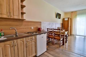 a kitchen with a sink and a table with chairs at Apartamenty w Istebnej in Istebna