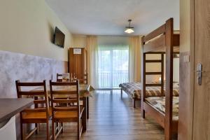 a room with a dining table and a bunk bed at Apartamenty w Istebnej in Istebna