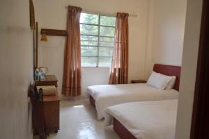a bedroom with two beds and a window at Skyville Zen Resort,Kundasang in Kundasang