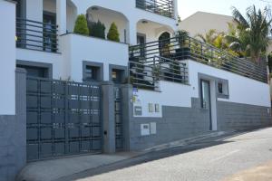 um portão em frente a um edifício com palmeiras em Sea and Sun 4 You - Choupana Studio no Funchal