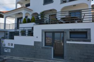 ein weißes Haus mit einem Balkon an der Seite in der Unterkunft Sea and Sun 4 You - Choupana Studio in Funchal