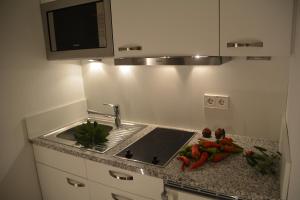 a kitchen counter with a sink and a microwave at Ferienwohnung Sautter in Beuren