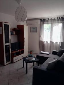 a living room with a couch and a table at Apartman Merula in Mali Lošinj