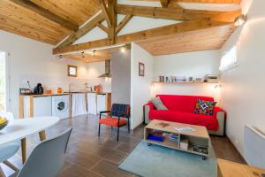 sala de estar con sofá rojo y cocina en SAUNA - JACUZZI - 100% PRIVÉ - L'ESTANTADA, en Linxe