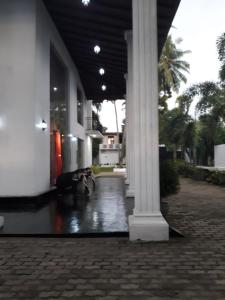 un edificio con una colonna al centro di un cortile di The Kingston Hotel a Kiribathgoda