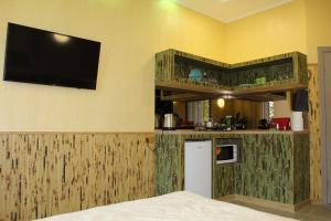a room with a kitchen and a tv on the wall at апартаменты GREENWOOD in Odesa
