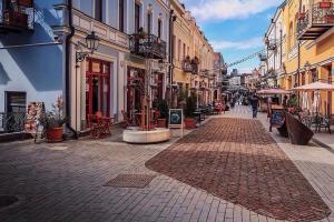 a cobblestone street with buildings and tables and chairs at Jessi on Marjanishvili in Tbilisi City