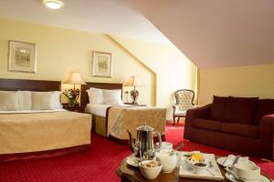 a hotel room with two beds and a couch at Meadow Court Hotel in Loughrea