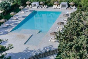 an overhead view of a swimming pool with chairs and umbrellas at Hotel Almirante in Alicante