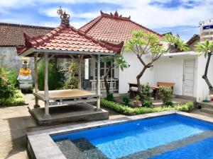 a house with a swimming pool and a gazebo at Narayana Homestay in Amed