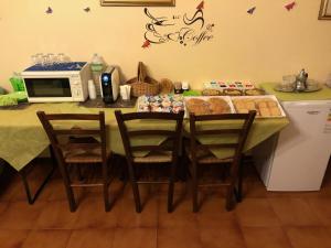 オルビアにあるB&B Le Mille E Una Notteのキッチン(テーブル、椅子、電子レンジ付)