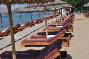 a row of chairs and umbrellas on a beach at Villa Anastasia in Keramoti