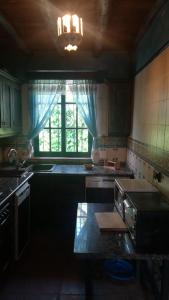 a kitchen with a sink and a stove and a window at El Cañuelo in Zahara de la Sierra