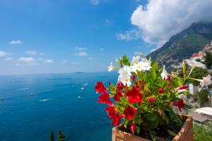
a vase filled with flowers sitting on top of a beach at Villa Pietra Santa in Positano
