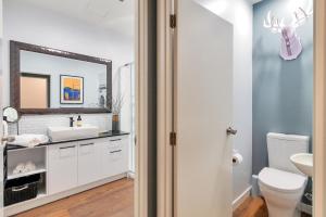 a bathroom with a white sink and a mirror at Chic Metro Apartment with Free Parking and Air-con in Auckland +13 photos