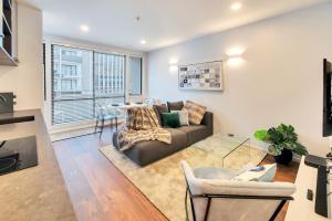 uma sala de estar com um sofá e uma mesa em Designer Styled City Apartment with Carpark em Auckland