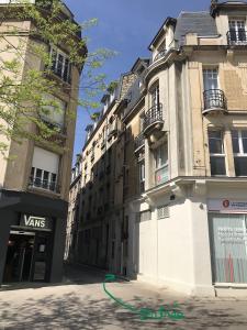 una strada con due edifici alti e un tubo verde di Les Berceaux de la Cathedrale a Reims