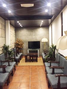 a lobby with chairs and a flat screen tv at Hotel Central Jardim in Geres