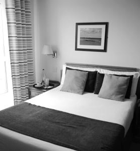 a black and white bedroom with a large bed at The Riviera Hotel & Apartments - Alum Chine in Bournemouth