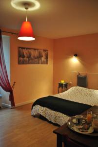 1 dormitorio con 1 cama y luz roja en Le Beffroi Hôtel & Apart, en Tournon-dʼAgenais