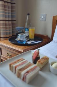 a plate with sandwiches and a tray of drinks on a bed at The Riviera Hotel & Apartments - Alum Chine in Bournemouth