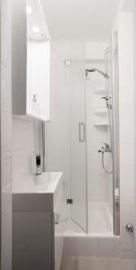a white bathroom with a sink and a shower at Apartment Marinis in Split