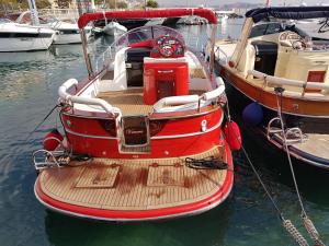a red boat is docked in the water at Hotel Argentina in Santa Margherita Ligure