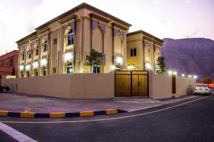ein Gebäude mit einem Tor vor einem Berg in der Unterkunft Esra Hotel Apartment in al-Chasab