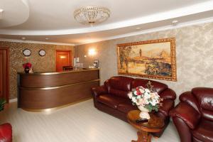 a waiting room with a leather couch and a courtroom at Comilfo in Magnitogorsk