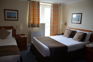 a hotel room with two beds and a window at The Riviera Hotel & Apartments - Alum Chine in Bournemouth