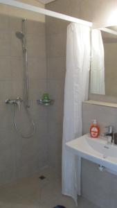 a white bathroom with a shower and a sink at BnB Erlach in Erlach