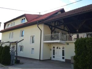 a large white house with a balcony on it at Vila Bbq in Ljubljana