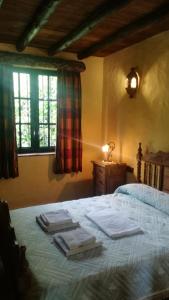 1 dormitorio con 1 cama con toallas en El Cañuelo, en Zahara de la Sierra