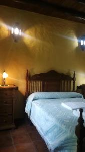 a bedroom with a bed and a dresser and lights at El Cañuelo in Zahara de la Sierra